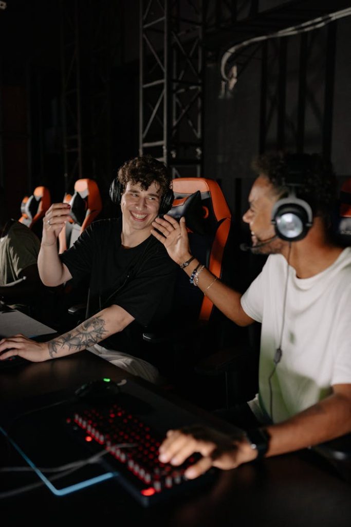 Group of young male gamers in gaming chairs enjoying an esports tournament indoors, wearing headphones and smiling.