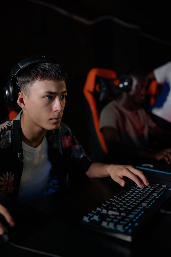 Teenagers engrossed in a competitive e-sports gaming session indoors with gaming setups.